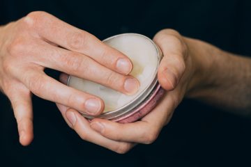 Un homme prend du baume à barbe avec sa main