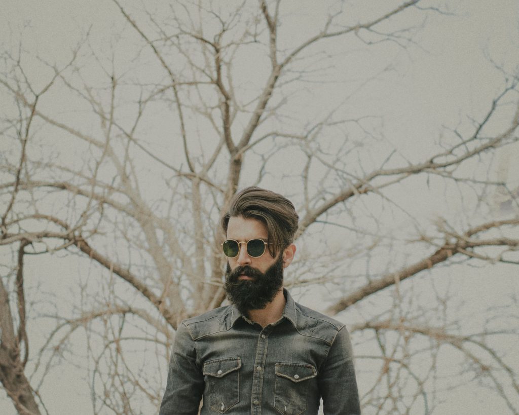 Homme à lunettes avec long barbe et cheveux soyeux