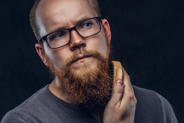 homme à lunette qui brosse sa barbe