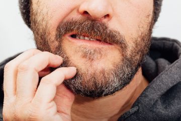 Homme qui se gratte la barbe avec gêne