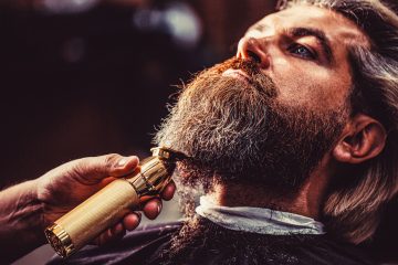 Homme qui se fait tondre la barbe dans un barber shop