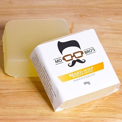 Shampoing barbe solide de la marque mo bro's posé sur une table, le savon a une couleur miel